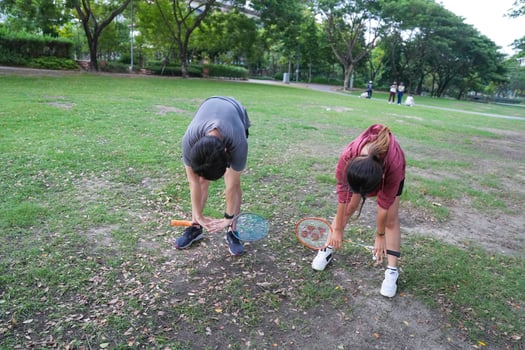 Young people play badminton and repair diligently in the park area. photo