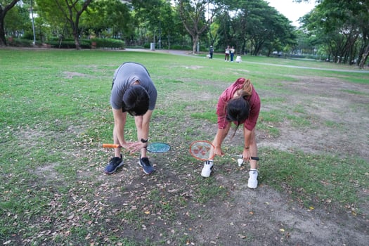 Young people play badminton and repair diligently in the park area. photo
