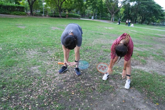 Young people play badminton and repair diligently in the park area. photo