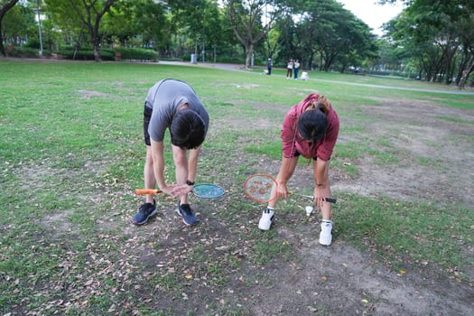 Young people play badminton and repair diligently in the park area. photo