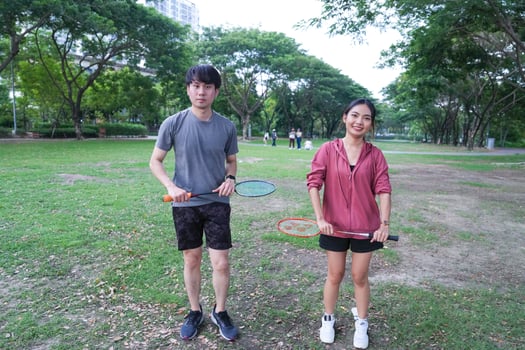 Young people play badminton and repair diligently in the park area. photo