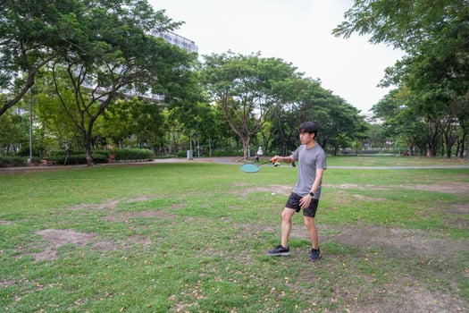 Young people play badminton and repair diligently in the park area. photo