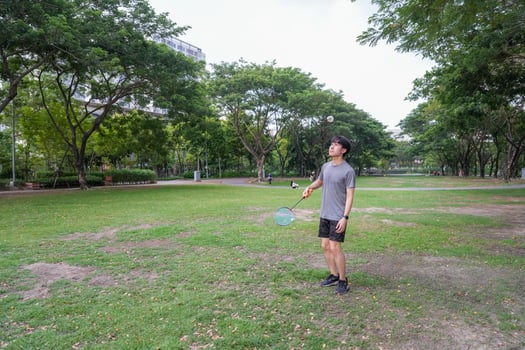 Young people play badminton and repair diligently in the park area. photo