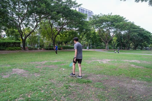 Young people play badminton and repair diligently in the park area. photo