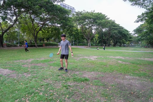 Young people play badminton and repair diligently in the park area. photo
