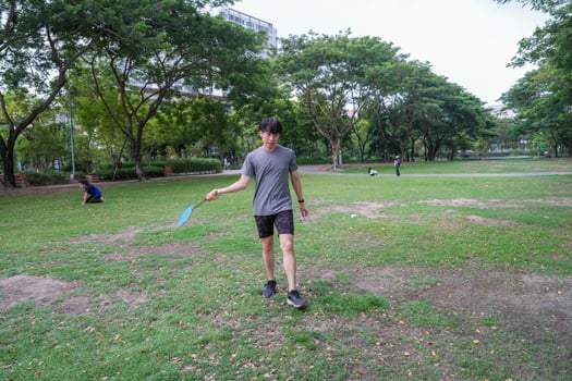Young people play badminton and repair diligently in the park area. photo