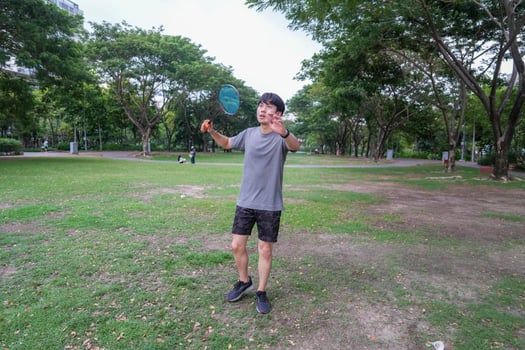 Young people play badminton and repair diligently in the park area. photo