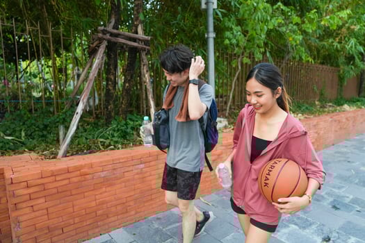 The male and female basketball players practice using the ball in the park court diligently and happily. photo