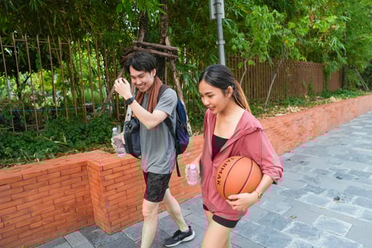 The male and female basketball players practice using the ball in the park court diligently and happily. photo