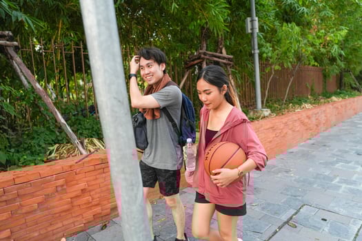 The male and female basketball players practice using the ball in the park court diligently and happily. photo