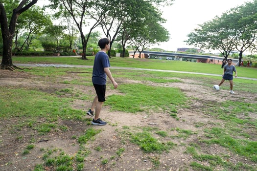 Asian man and woman are kicking and warming up before playing in soccer at outdoor park. photo