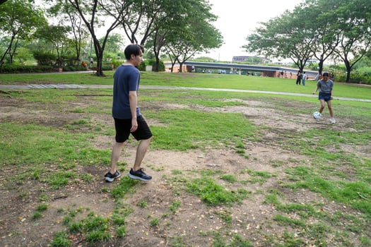 Asian man and woman are kicking and warming up before playing in soccer at outdoor park. photo