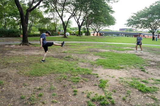 Asian man and woman are kicking and warming up before playing in soccer at outdoor park. photo