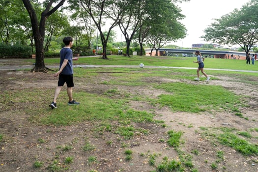 Asian man and woman are kicking and warming up before playing in soccer at outdoor park. photo