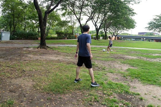 Asian man and woman are kicking and warming up before playing in soccer at outdoor park. photo