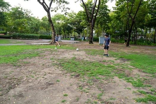 Asian man and woman are kicking and warming up before playing in soccer at outdoor park. photo