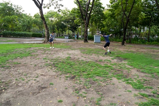 Asian man and woman are kicking and warming up before playing in soccer at outdoor park. photo