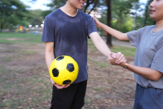 Male and female soccer players practice using the ball in the park field diligently and happily. photo