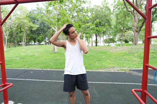 Asian man practicing gymnastics doing gymnastics bar and hoop exercises and stretching and resting for sports. photo