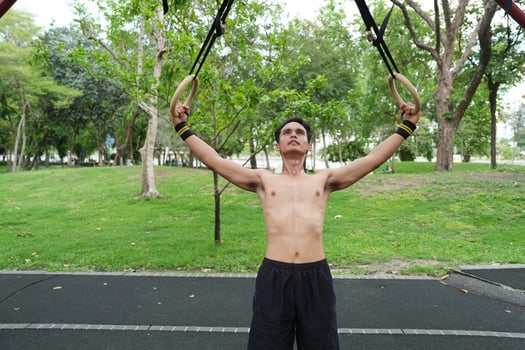 Asian man practicing gymnastics, doing gymnastics bar and hoop exercises and stretching, resting for sports. photo