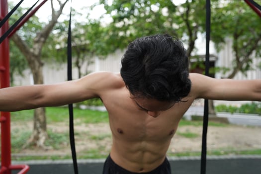 Asian man practicing gymnastics, doing gymnastics bar and hoop exercises and stretching, resting for sports. photo