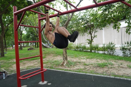 Asian man practicing gymnastics, doing gymnastics bar and hoop exercises and stretching, resting for sports. photo