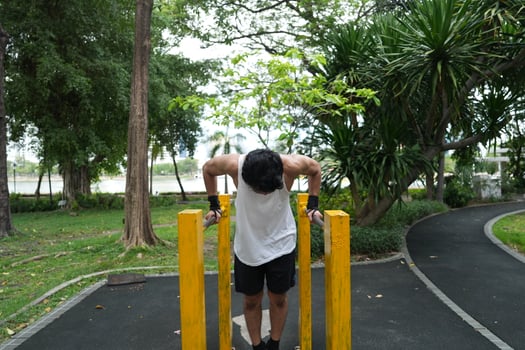 Asian man practicing gymnastics, doing gymnastics bar and hoop exercises and stretching, resting for sports. photo