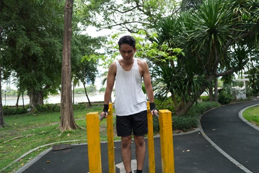 Asian man practicing gymnastics, doing gymnastics bar and hoop exercises and stretching, resting for sports. photo