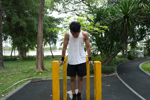 Asian man practicing gymnastics, doing gymnastics bar and hoop exercises and stretching, resting for sports. photo