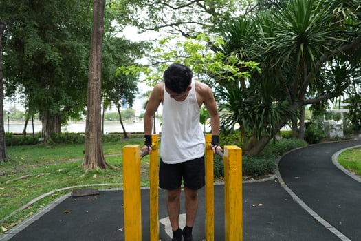 Asian man practicing gymnastics, doing gymnastics bar and hoop exercises and stretching, resting for sports. photo