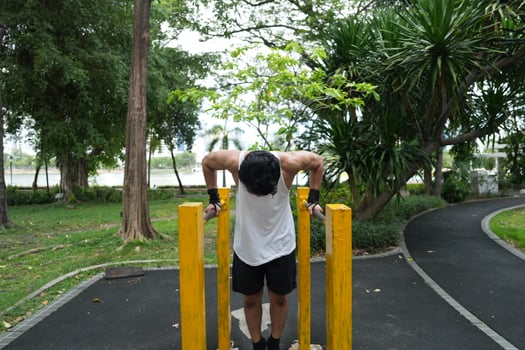 Asian man practicing gymnastics, doing gymnastics bar and hoop exercises and stretching, resting for sports. photo