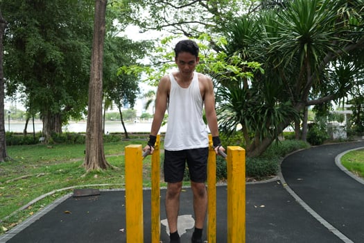 Asian man practicing gymnastics, doing gymnastics bar and hoop exercises and stretching, resting for sports. photo