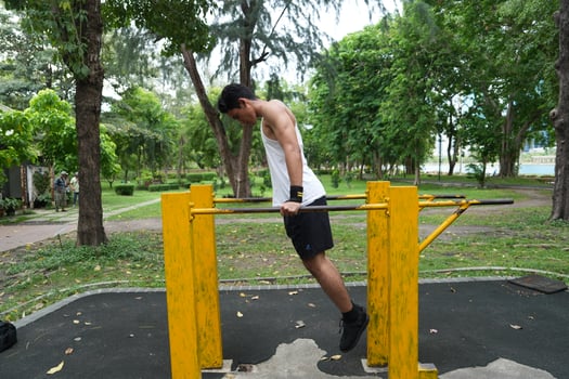 Asian man practicing gymnastics, doing gymnastics bar and hoop exercises and stretching, resting for sports. photo