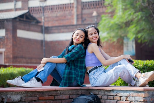 Fashionable Ladies Closing Her Eyes and Sitting Back-to-Back photo