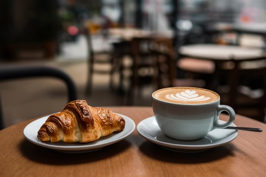 a croissant and a cappuccino on a table photo