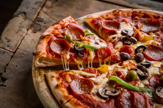 a pizza with pepperoni, olives, peppers and mushrooms photo