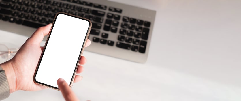 Hand of woman using smartphone over workplace photo