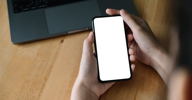 oman hand holding smartphone on workplace. Blank screen mobile phone for graphic display montage.. photo