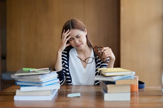Portrait young stressed displeased worried student woman while reading book for exam. photo