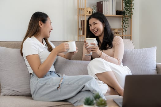 Happy young asian women LGBT lesbian happy couple sitting on sofa using laptop a computer in living room at home. LGBT lesbian couple together photo