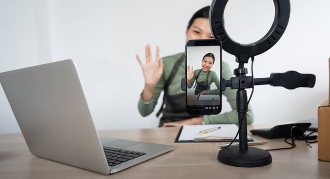 Beautiful asian woman blogger in front of camera to recording vlog live streaming at her shop. Business online influencer on social media concept. Online Selling. Online Shopping photo