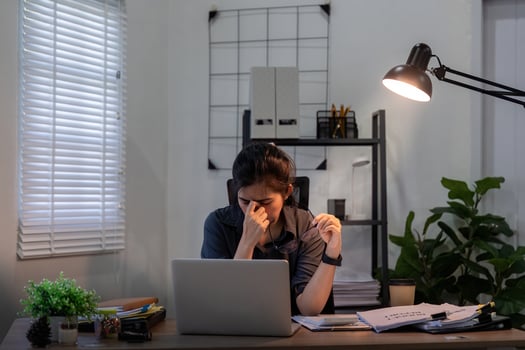 Business woman asian in office, tired or fatigue while working late at night on laptop computer. Burnout, migraine and female person with depression, anxiety or brain fog, stress and deadline photo