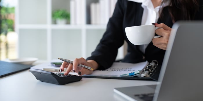 Businesswoman accountant using calculator and laptop for financial data saving in office room, Business financial, tax, accounting concept photo