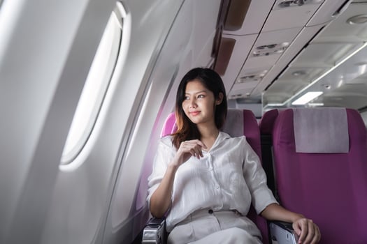 Businesswoman smiling while sitting in airplane seat. Concept of business travel and professional journey photo