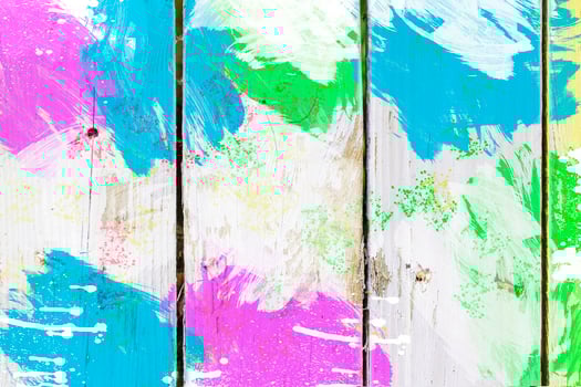 Old boards covered with bright multi-colored paints. Cheerful wooden background of bright fence. photo