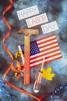 Inscription Happy labor day, american flag, hammer, screwdriver and autumn leaves on a blue background photo