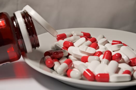 white and red pills in a plate. close-up. the concept of health, treatment. photo