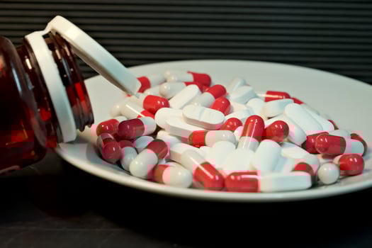 white and red pills in a plate. close-up. the concept of health, treatment. photo