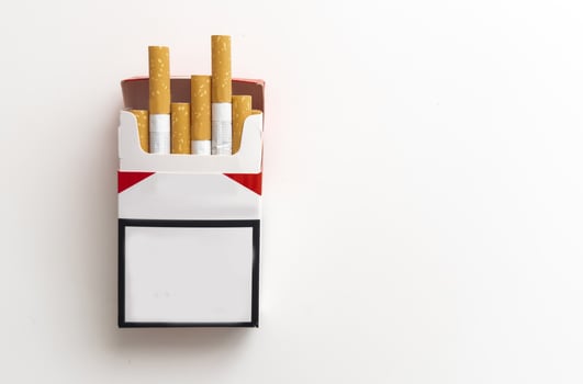 Open pack of cigarettes and a cigarette on a white background. photo