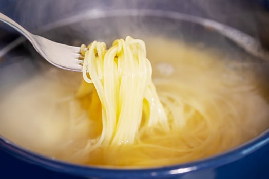 Spaghetti is cooked in boiling water in a saucepan photo
